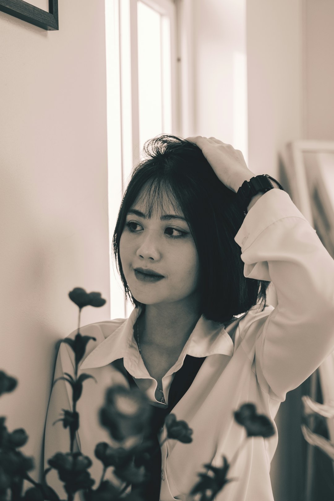 Businesswoman in a white shirt and tie posing against a wall.